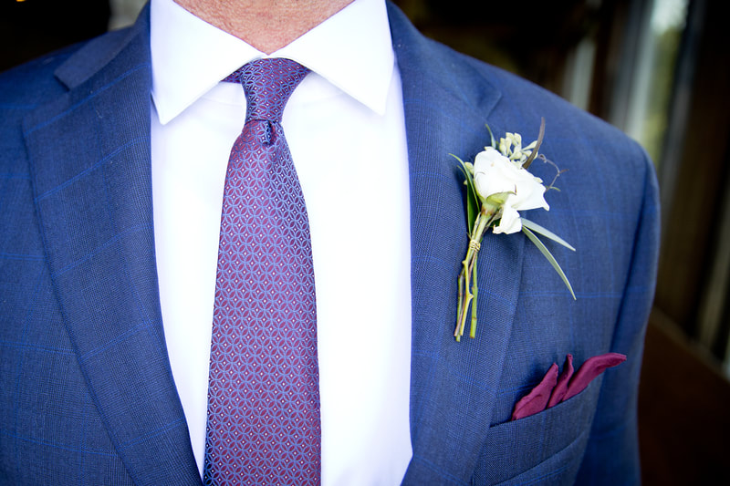A close-up of a groom's wedding outfit.