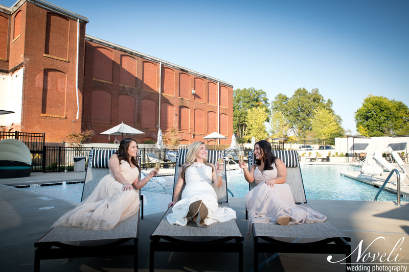 A bride and her bridesmaids lounge by the Judson Mill pool